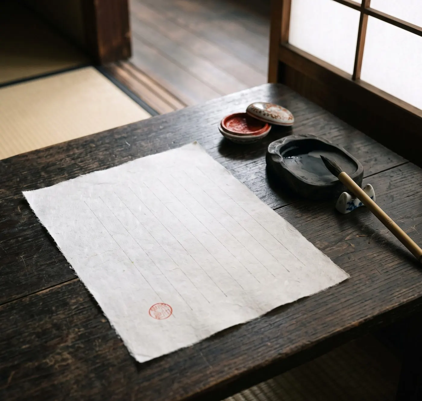 朱の印を押した一枚の和紙と、筆と硯