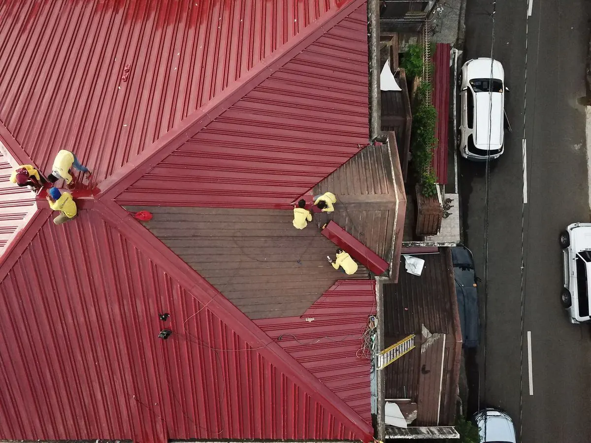 上空から見た赤い金属屋根の修理作業